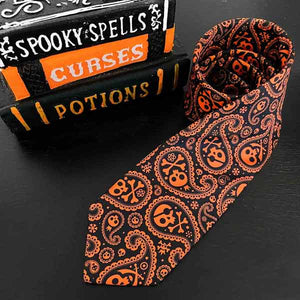 A skull and crossbones paisley Halloween tie in black and orange
